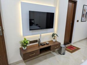 a living room with a television on a wall at Hotel cressida green palace - near redisson squar in Indore