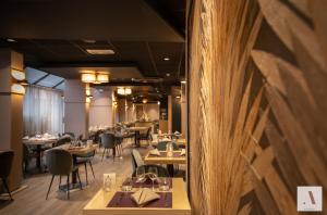 a restaurant with wooden walls and tables and chairs at Kyriad Hotel Nevers Centre in Nevers