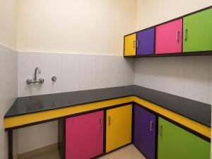 a room with colorful cabinets and a sink at Cross Hill House Mussoorie in Mussoorie