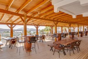 a restaurant with wooden tables and chairs on a deck at Bodrum Fora Holiday Resort in Bodrum City