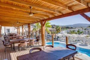 a patio with tables and chairs and a pool at Bodrum Fora Holiday Resort in Bodrum City