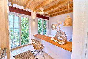 a room with a counter with chairs and windows at Billion Stars Studio in Thymonia Beach