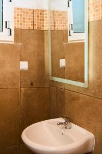 a bathroom with a sink and a mirror at Billion Stars Studio in Thymonia Beach