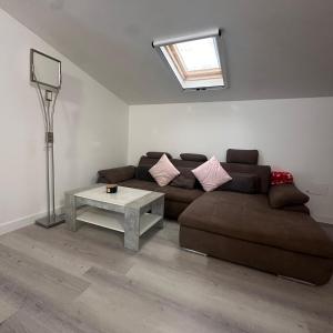 a living room with a brown couch and a table at Deluxe apartment 2 rooms , near Koper and Trieste in Plavje