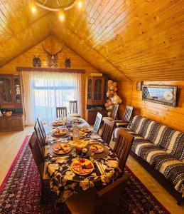 a dining room with a table and a couch at Casa Izvorul Muntelui in Sadova