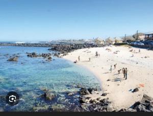a group of people on a beach near the water at Maison dans le quartier de terre sainte Nicolas in Saint-Pierre