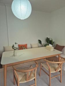 a dining room table with two chairs and a couch at 곁 Stay in Seoul