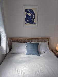 a bed with a blue pillow and a picture on the wall at 곁 Stay in Seoul