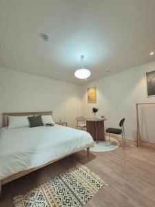 a bedroom with a bed and a desk and a chair at 곁 Stay in Seoul