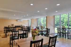 a restaurant with wooden tables and chairs and flowers at Brido in Bardo