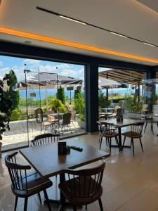 a restaurant with tables and chairs and a view of the ocean at Hotel Restorant Binjaket in Pogradec