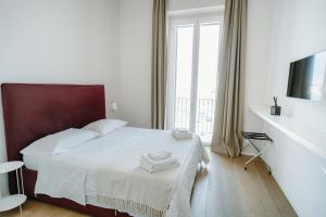 a white bedroom with a bed and a window at La Finestrella in Bari