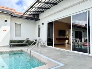 a house with a swimming pool and a patio at Phuket La Siesta, Naiharn Beach in Nai Harn Beach