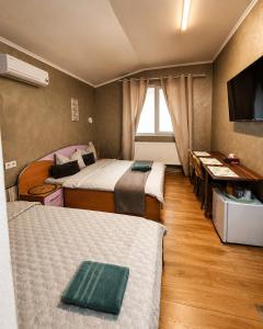 a hotel room with two beds and a television at Agape Speranta 96 in Piteşti