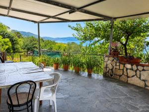a patio with a table and chairs and a stone wall at Appartamenti Villa Verde in Caprioli