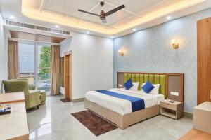 a bedroom with a king sized bed and a chair at Hotel Saathviik99 in Tehri-Garhwāl