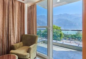 a living room with a chair and a large window at Hotel Saathviik99 in Tehri-Garhwāl