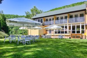a patio with chairs and umbrellas in front of a building at Brido in Bardo