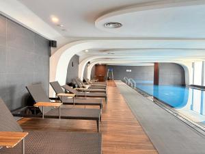 a swimming pool with a row of chairs in a hotel lobby at Mai home in Hai Phong