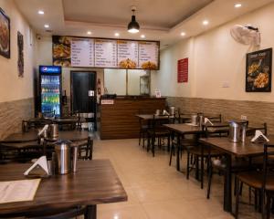 a dining room with tables and chairs in a restaurant at Stay By Shree Dharan Inn Near Shree Ram Mandir Ayodhya in Ayodhya