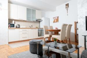 a kitchen and dining room with a table and chairs at Apartman "JOKA" in Đakovo
