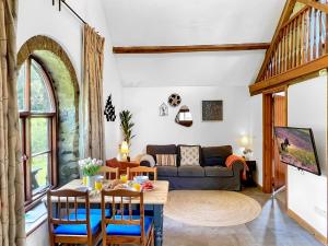 a living room with a table and a couch at Smiddy Cottage Hawkridge in Dulverton
