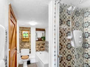 a bathroom with a shower and a toilet and a sink at Smiddy Cottage Hawkridge in Dulverton +34 photos