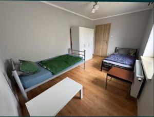 a small room with two beds and a table at Hostel Lubawa in Lubawa
