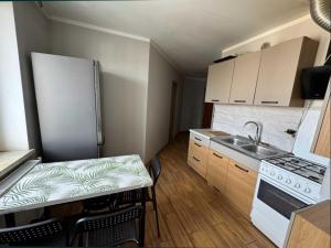 a small kitchen with a table and a refrigerator at Hostel Lubawa in Lubawa