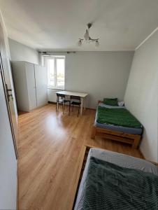 a room with two beds and a table in it at Hostel Lubawa in Lubawa