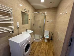 a bathroom with a shower and a toilet and a sink at Hostel Lubawa in Lubawa
