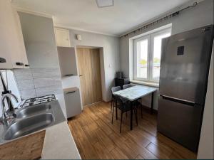 a kitchen with a stainless steel refrigerator and a table at Hostel Lubawa in Lubawa
