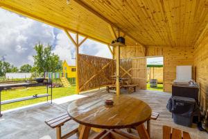ein großer Holzraum mit einem Holztisch und Stühlen in der Unterkunft Lark Nest in Novaci-Străini