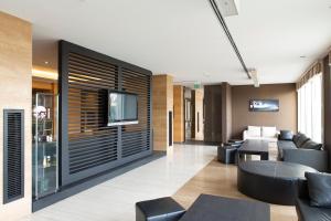 salon z czarnymi meblami i telewizorem na ścianie w obiekcie Hotel Pineta Wellness & Spa w mieście Ruvo di Puglia