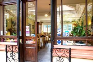 uma porta aberta de um restaurante com uma mesa em Hôtel Restaurant Les Touristes em Vals-les-Bains