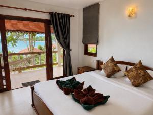 a bedroom with a bed and a window with a view at Bounty Resort in Haad Son