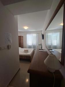 a bedroom with a bed and a desk and a mirror at San Lorenzo in Lopar