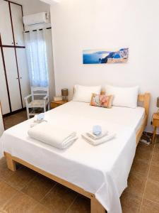 a bedroom with a large white bed with towels on it at Mamas House Spetses in Spetses