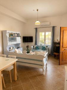 a living room with a couch and a tv at Mamas House Spetses in Spetses