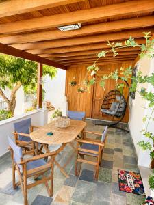 a patio with a wooden table and chairs at Mamas House Spetses in Spetses