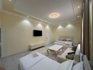 a room with two beds and a tv on the wall at Jahanshah GuestHouse in Samarkand +21 photos