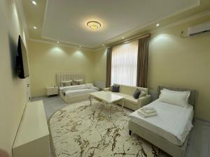 a living room with two beds and a couch at Jahanshah GuestHouse in Samarkand