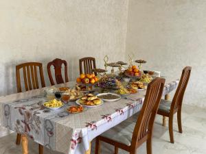 a table full of food on a table with chairs at Aina guesthouse in Kyzyloy +64 photos