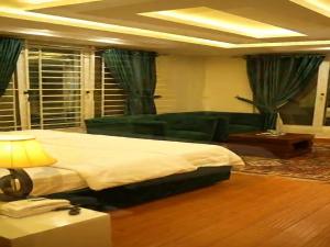 ein Schlafzimmer mit einem großen Bett und einer Couch in der Unterkunft Down Town in Nathia Gali