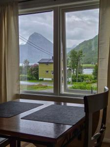 ein Fenster mit einem Tisch und Blick auf einen Berg in der Unterkunft Bergsbu in Senja