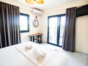 a bedroom with a bed with towels on it at Novus apartments in Skala Marion
