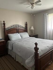 a bedroom with a large bed with a ceiling fan at Three Pines Private Bedroom Suite in Moncton