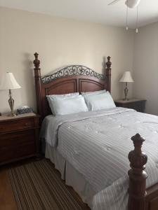 a bedroom with a large bed with two night stands and two lamps at Three Pines Private Bedroom Suite in Moncton