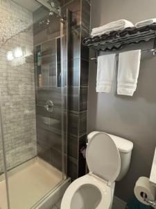 a bathroom with a toilet and a shower with towels at Three Pines Private Bedroom Suite in Moncton
