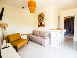 a living room with a couch and a chair at Novus apartments in Skala Marion